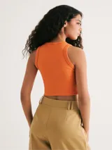 Top corto marrón de tela acanalada, con cuello redondo y sisas anchas.