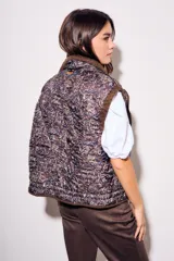 Chaleco reversible de algodón con acabado lavado y diseño acolchado con pespuntes ondulados. Presenta cuello alto con cordón ajustable, cierre frontal de cremallera y botones a presión, bolsillos delanteros tipo parche y cordón de ajuste en el bajo.