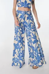 Pantalón palazzo de tiro alto con estampado floral en tonos beige y azul.