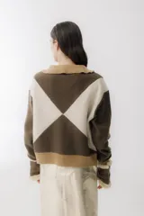 Bomber de lana hervida color marrón y blanco con diseño de rombos grandes, cierre frontal y cuello tejido en rib color beige.