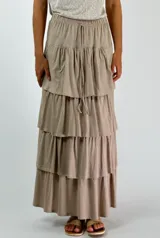 Pollera larga color beige con cintura elastizada y corte escalonado con volados.