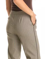 Pantalón de gabardina elastizada con estampado cuadrillé en tonos beige y negro. Modelo recto con pretina elastizada, bolsillos inclinados en la parte delantera y ribete en contraste en el lateral de la pierna.