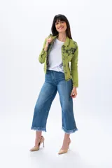 Campera de jean verde con efecto tie dye en negro, corte clásico, cuello camisero, cierre frontal con botones metálicos y bolsillos con solapa en el pecho.