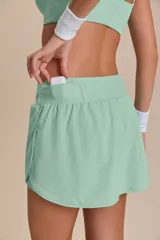 Pollera deportiva color verde lima, con short interno y bolsillo en la cintura.