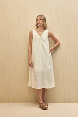 Vestido midi color crudo, sin mangas, con escote en V y detalle de nudo en el frente.