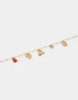 Collar corto dorado con cadena de eslabones y dijes colgantes: mariquita, trébol de cuatro hojas, herradura, corazón y cerezas.