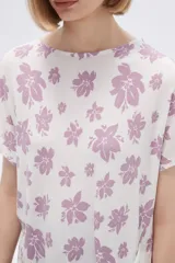Remera blanca con estampado floral en color lila, de corte holgado y mangas cortas.