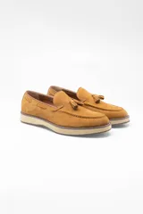Mocasines color marrón claro, de gamuza, con borlas y suela de goma.