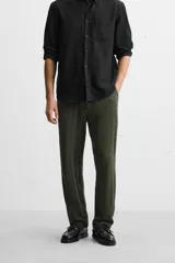 Pantalón verde oscuro con textura de rayas verticales, corte relaxed fit, cintura elástica ajustable con cordón, bolsillos delanteros y bolsillo trasero de parche.