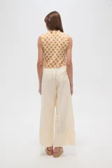 Pantalón viscosa color crudo, de corte recto y tiro alto, con cintura elastizada ajustable con cordón.