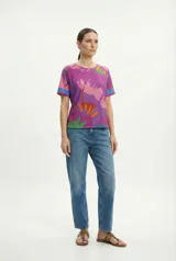 Remera lila con estampado de flores abstractas en tonos rosa, naranja, amarillo y verde.