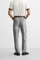 Pantalón de jean celeste de corte slim fit y tapered, con cinco bolsillos, efecto lavado y cierre frontal con cremallera y botón.