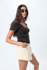 Remera color beige de punto acanalado, con escote redondo amplio y mangas cortas.