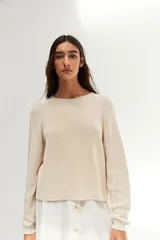 Sweater de punto color crudo, de corte recto y mangas largas.