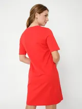 Vestido rojo de algodón con cuello redondo y mangas cortas. Presenta un logo de Tommy Hilfiger bordado en blanco en el pecho y la bandera de la marca bordada en la manga.