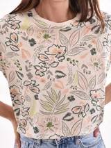 Remera blanca con estampado de flores y hojas en tonos pastel.