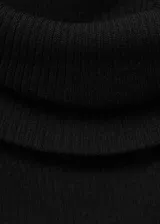 Vestido largo negro de tejido fluido con hombros descubiertos y mangas largas.