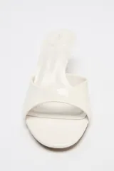 Sandalia tipo mule de charol color blanco, con tira delantera y tacón fino medio.