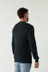 Sweater azul marino de punto con cuello redondo, mangas largas y logo bordado en el pecho.