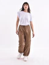 Pantalón marrón de corte ancho, con cintura elástica ajustable con cordón, bolsillos laterales y bolsillos tipo cargo en los muslos.