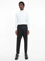 Camisa blanca de poplin con corte relaxed, mangas largas, cierre frontal con botones y bolsillo con solapa.