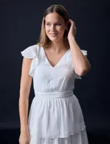 Vestido blanco de gasa con capas de la marca Julia Jordan. Tiene escote en V, mangas cortas con volados, corte en la cintura, abertura central en la espalda con cierre invisible y forro interno a tono.