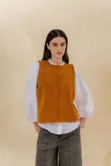 Chaleco tejido color mostaza con bordado artesanal en forma de V.