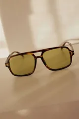 Lentes de sol estilo aviador con armazón carey y lentes grises.