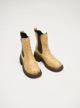 Botas Chelsea color beige con estampado floral, elástico lateral marrón y suela track color marrón.