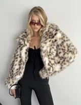 Tapado corto de piel sintética con estampado animal print, corte recto, largo a la cadera, interior forrado y ganchos internos para cerrar.