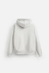 Sudadera con capucha gris confeccionada en tejido de algodón con interior rizo. Tiene manga larga, bolsillo frontal tipo canguro y acabados en rib.