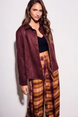 Camisa color marrón de gamuza sintética, de corte recto, con cuello clásico, cierre frontal con botones y mangas largas.