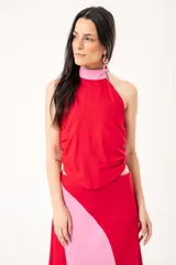 Top halter bicolor en rojo y fucsia, confeccionado en lino imperial, con espalda descubierta y bajo asimétrico.
