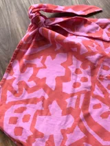 Minifalda pareo estampada en tonos rosa y naranja, con lazo lateral para atar.