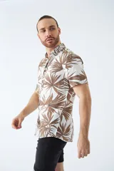 Camisa de hombre de manga corta, estampada con motivos tropicales, con ajuste slim y cierre de botones.