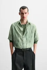 Camisa verde agua con estampado abstracto, corte relaxed fit, cuello solapa, manga corta y cierre frontal con botones.