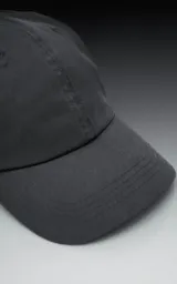 Gorra de béisbol de seis paneles, color gris oscuro o carbón, con visera curva y botón superior.
