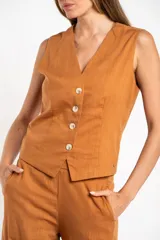 Chaleco negro con escote en V y cierre frontal con botones.