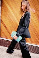 Blazer negro de cuello solapa y manga larga con hombreras. Presenta bolsillos de vivo en delantero y pecho, aberturas en espalda con botón y forro interior a tono.