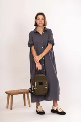 Mochila pequeña color verde militar de nylon con cierres metálicos, logo de goma y detalles de cordones combinados.