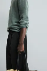Sweater azul de punto con textura, corte holgado, cuello redondo y mangas largas con puños acanalados.