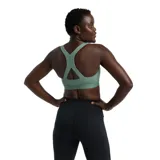 Top deportivo New Balance color verde agua, de soporte medio, ideal para entrenamientos como gym, boxeo y ciclismo. Con tecnología NB DRY que mantiene la piel seca, copas removibles y banda elástica que brinda comodidad y sujeción.