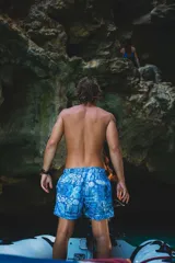 Traje de baño azul con estampado tropical, elástico en la cintura y tres bolsillos.