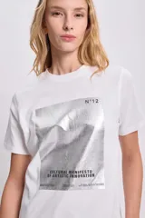 Remera blanca de corte recto y mangas cortas, con estampa rectangular en el frente con imagen abstracta en tonos plateados y texto "Cultural Manifesto of Artistic Innovation".
