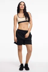 Short deportivo color bordó de tela satinada con cintura elastizada, bolsillos laterales y franja lateral blanca.