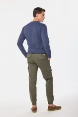 Pantalón cargo de color verde militar, con múltiples bolsillos y ajuste en los tobillos.