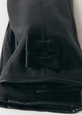 Par de guantes de cuero color borgoña, con forro interior y detalle de lazo en la parte superior. Uno de los guantes tiene la punta del dedo índice compatible con pantallas táctiles.