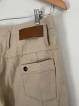 Pantalón marrón de lino y algodón, de tiro medio y piernas anchas, con bolsillos delanteros y traseros con detalles de remaches.