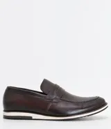 Zapato masculino de cuero color marrón oscuro, modelo slip on con suela blanca.