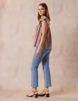 Blusa color marrón claro de algodón con bordados y calados blancos. Tiene cuello a la base, escote en V con lazo de ajuste y mangas cortas amplias.